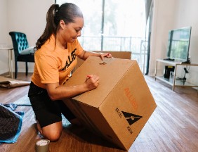 Allied employee labelling a moving box 