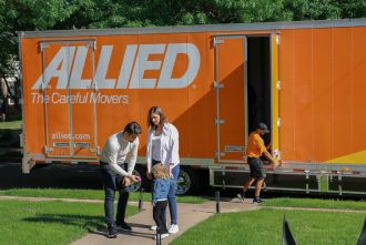 Young family in front of Allied Van Lines moving truck