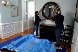 Movers packing up a wall mirror