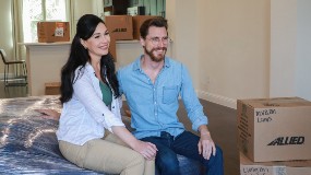 Couple sitting in room with moving boxes