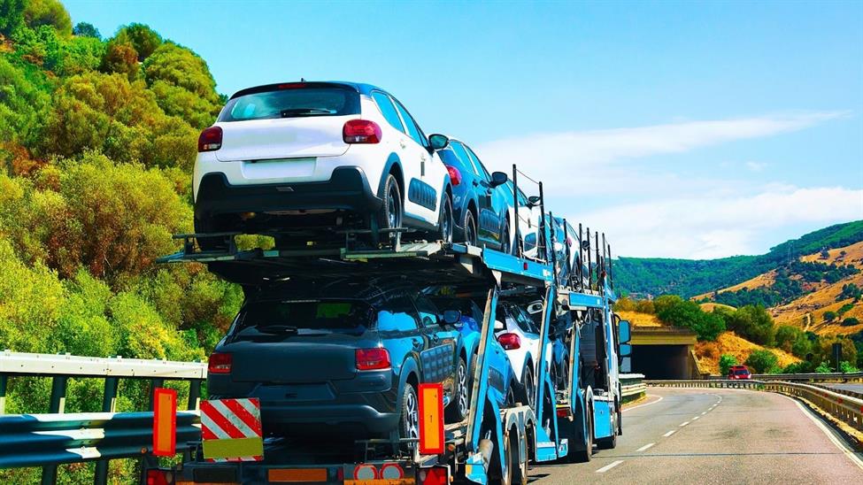 Car carrier trailer traveling down a highway