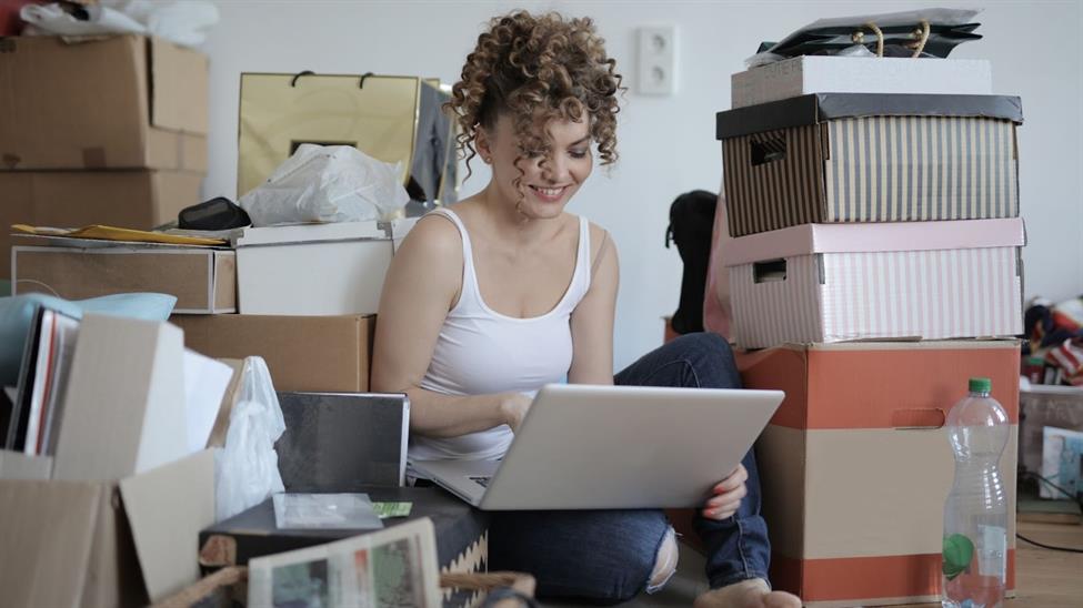 Woman on laptop surrounded by boxes
