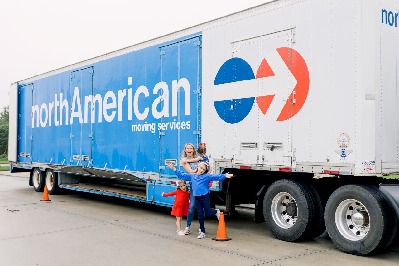 Family standing in front of a North American Moving Services truck