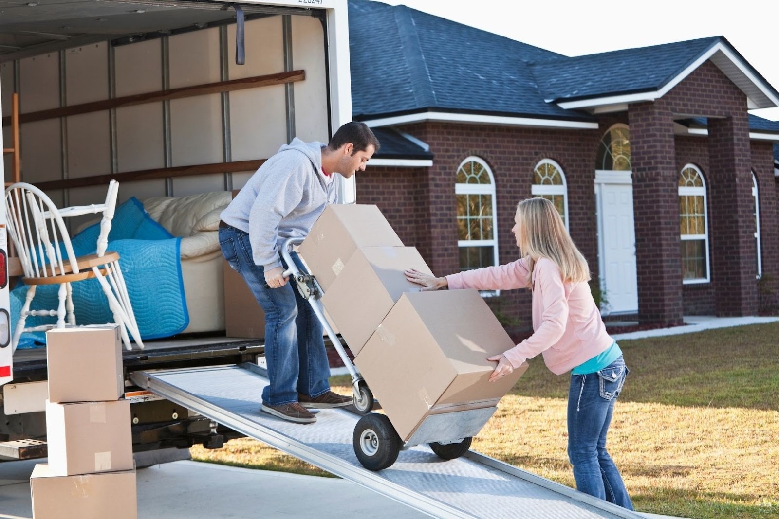 couple-moving-boxes-into-truck Couple moving boxes into back of truck