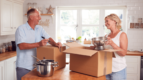 Couple packing kitchen items for a move