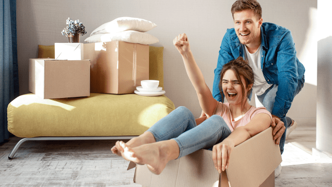 Man and woman having fun with moving boxes