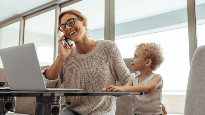 Woman talking on phone with son by her side