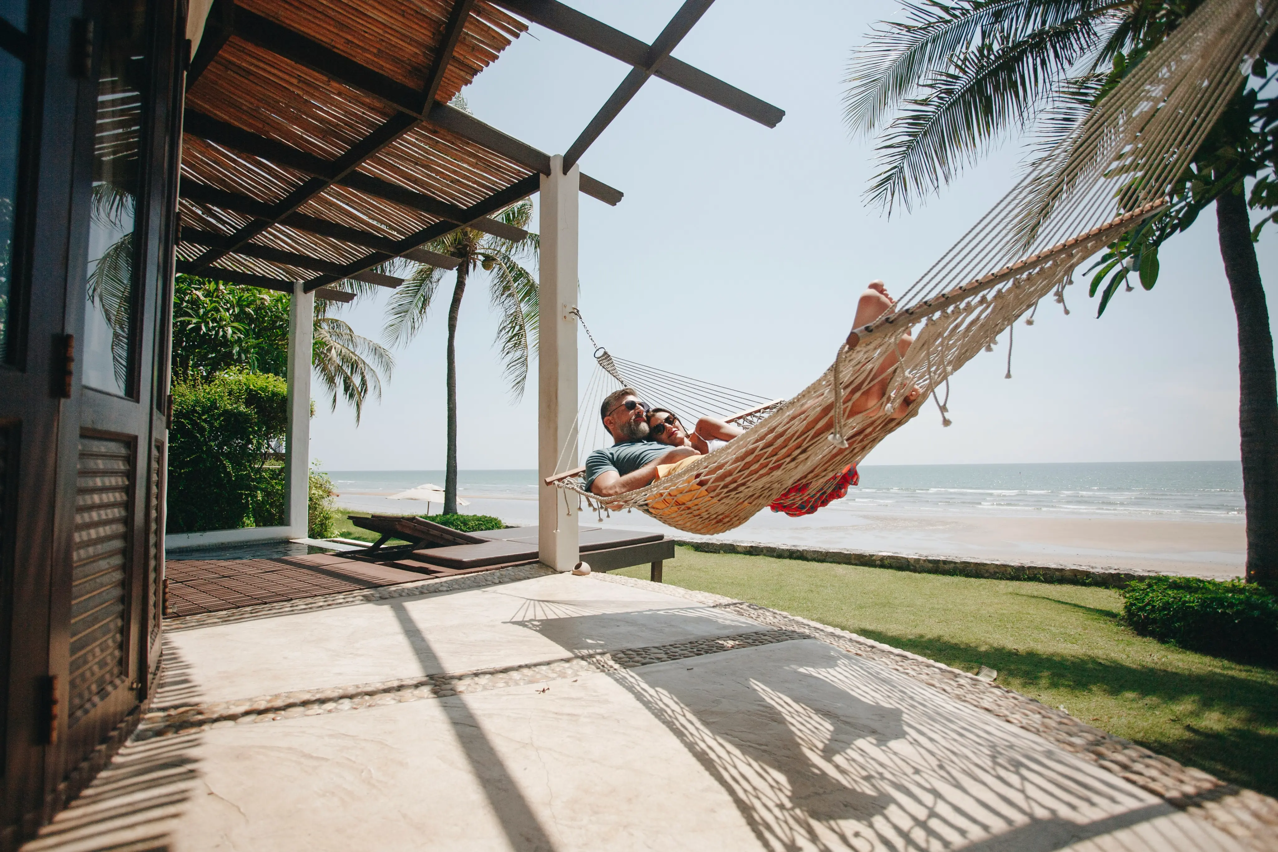 couple lounging in a hammock on the beach